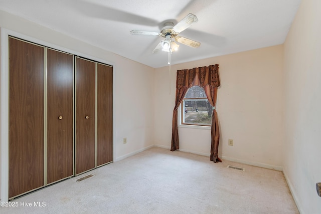 unfurnished bedroom featuring baseboards, visible vents, light carpet, and a closet