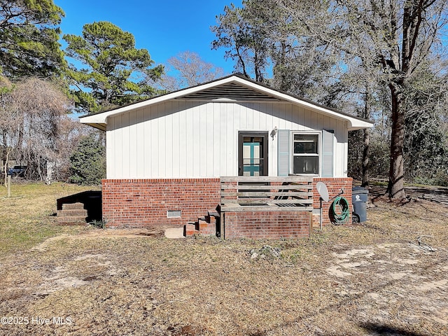 view of side of home with brick siding and crawl space