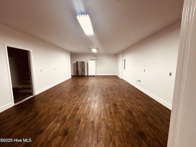 spare room with dark wood-style flooring and baseboards