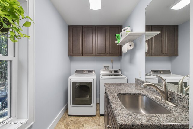 laundry area with independent washer and dryer, cabinet space, and baseboards