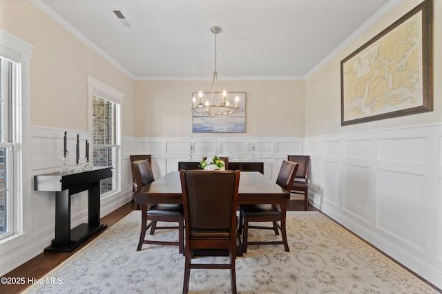 dining room with visible vents, a healthy amount of sunlight, and wood finished floors