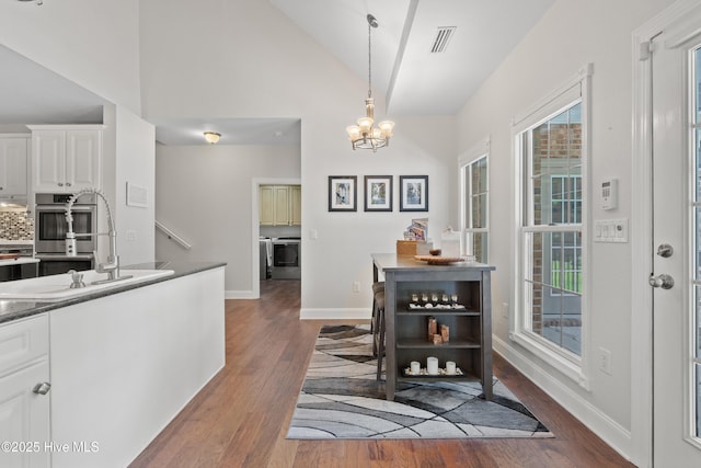 dining room featuring baseboards, plenty of natural light, an inviting chandelier, and wood finished floors