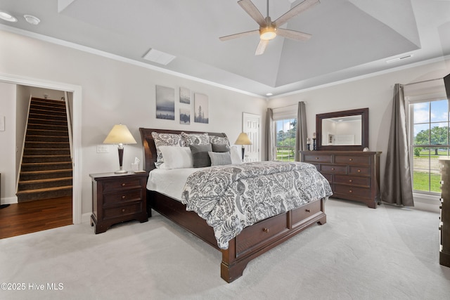 bedroom featuring visible vents, ceiling fan, ornamental molding, vaulted ceiling, and light carpet