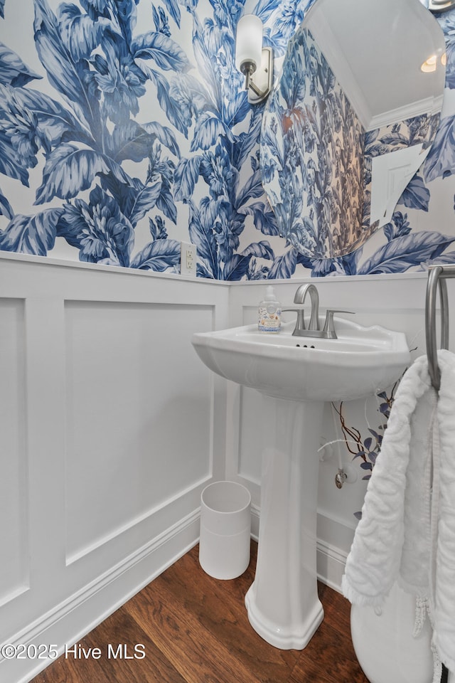 bathroom with crown molding and wood finished floors