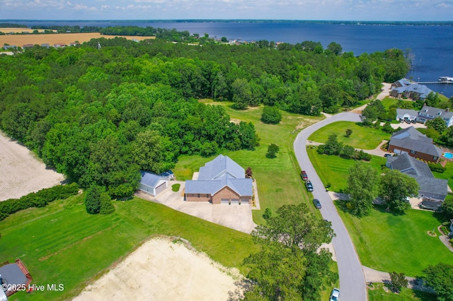 birds eye view of property with a wooded view and a water view