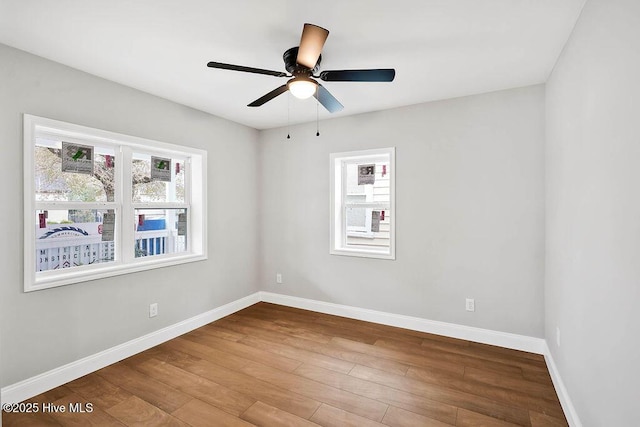 empty room with a ceiling fan, baseboards, and wood finished floors