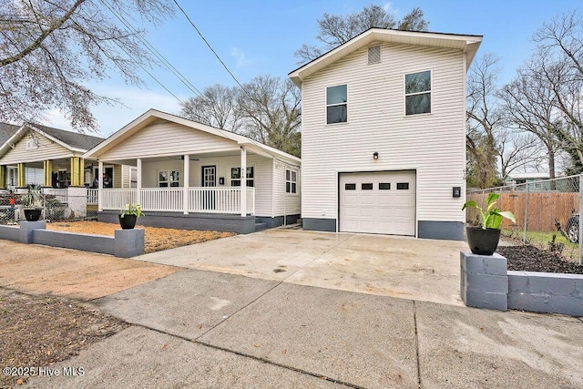 traditional-style home with a porch, an attached garage, fence, and concrete driveway