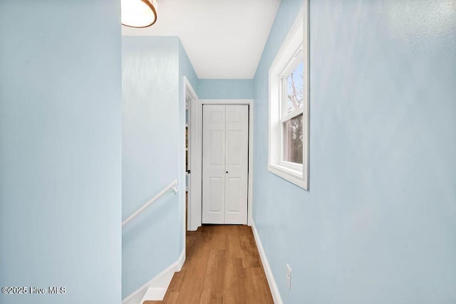 corridor with baseboards and wood finished floors