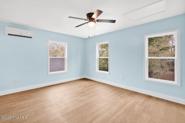 unfurnished room featuring wood finished floors, a ceiling fan, baseboards, and a wealth of natural light