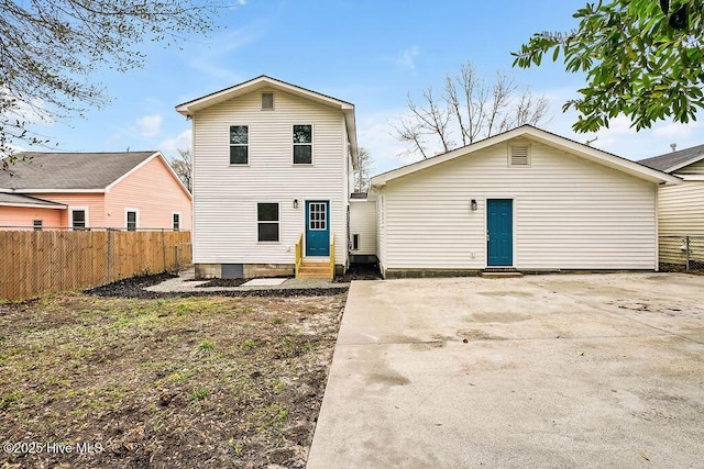 rear view of house with fence and entry steps