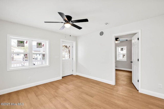 unfurnished room featuring light wood finished floors, baseboards, and a ceiling fan