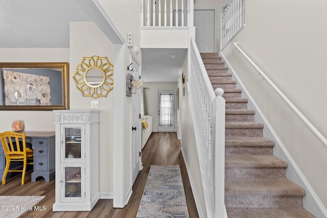 stairs featuring wood finished floors and baseboards