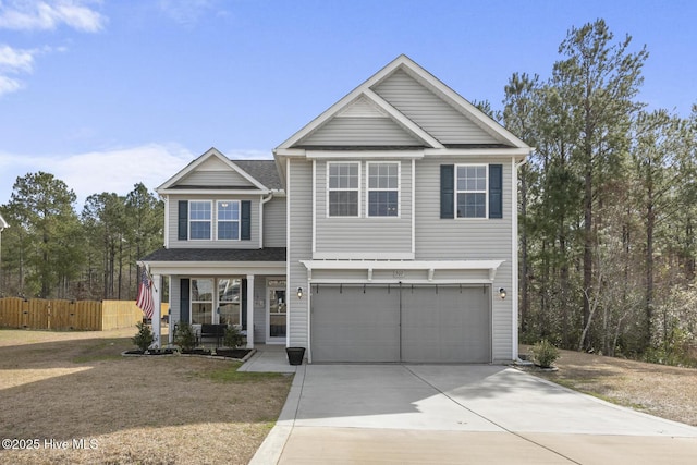 view of front of property with covered porch, concrete driveway, a garage, and fence