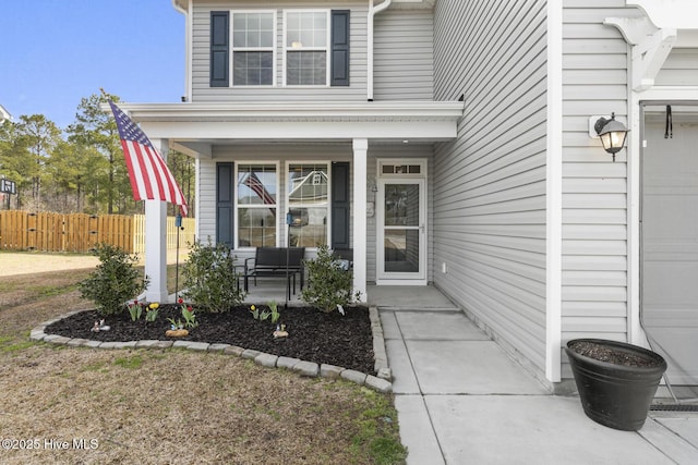 property entrance featuring a porch and fence