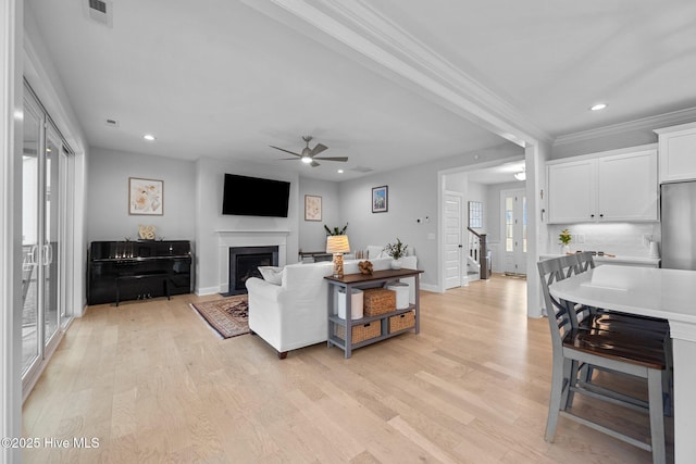 living area with visible vents, a healthy amount of sunlight, and light wood-style floors