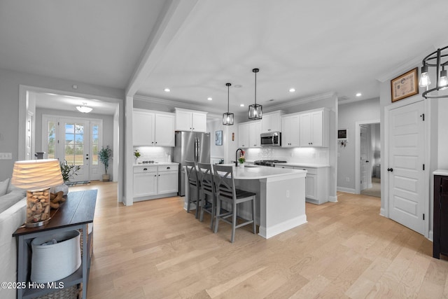 kitchen featuring tasteful backsplash, stainless steel appliances, light countertops, and light wood-style floors