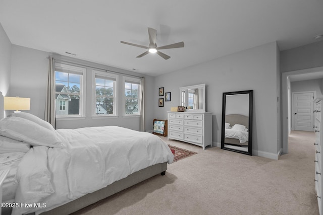 bedroom with ceiling fan, light colored carpet, visible vents, and baseboards