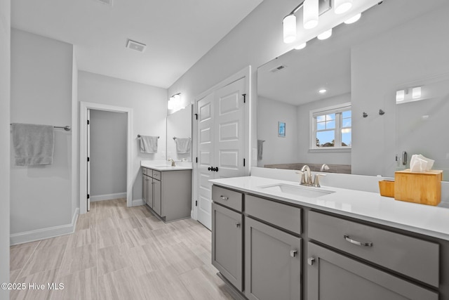 bathroom with two vanities, visible vents, and a sink