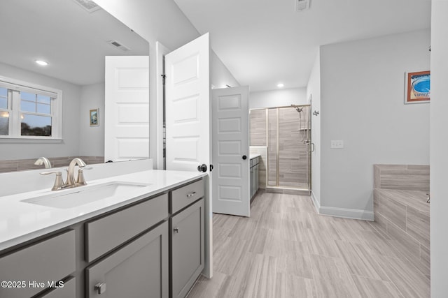 bathroom featuring visible vents, baseboards, a stall shower, and vanity