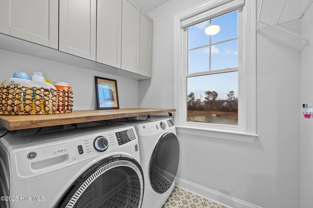 clothes washing area with washer and clothes dryer, cabinet space, tile patterned floors, and baseboards