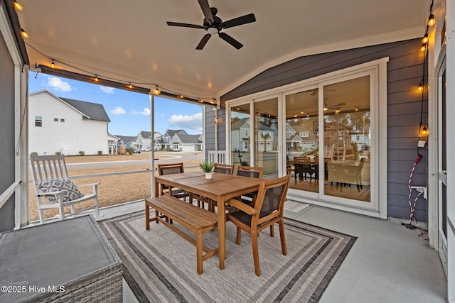 sunroom featuring vaulted ceiling, a residential view, and ceiling fan