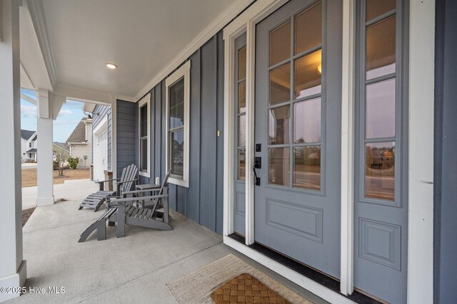 view of exterior entry with a residential view and a porch