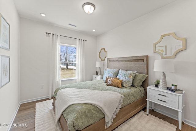 bedroom with recessed lighting, visible vents, baseboards, and wood finished floors