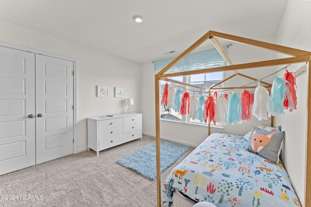 carpeted bedroom with baseboards, visible vents, and a closet