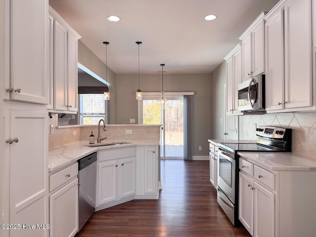 kitchen with a sink, appliances with stainless steel finishes, a peninsula, and white cabinetry