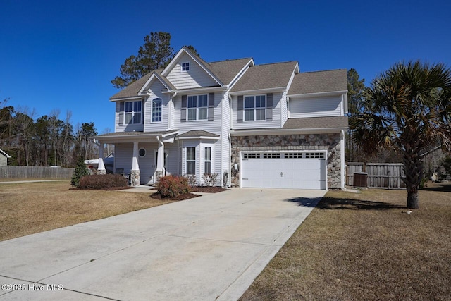 view of front of home with fence, cooling unit, a garage, stone siding, and driveway