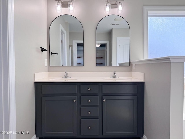 bathroom with a sink, visible vents, and double vanity