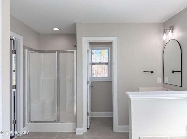 bathroom with vanity, tile patterned floors, baseboards, and a stall shower