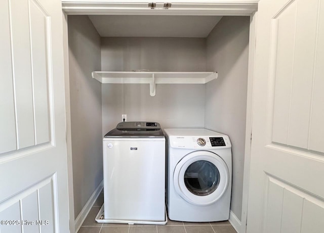 laundry room with tile patterned flooring, laundry area, washer and dryer, and baseboards