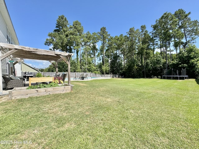 view of yard featuring a trampoline, a fenced in pool, and fence