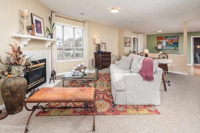 living area featuring carpet, a fireplace, and baseboards