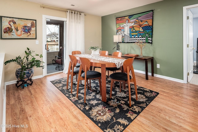 dining area with baseboards and wood finished floors