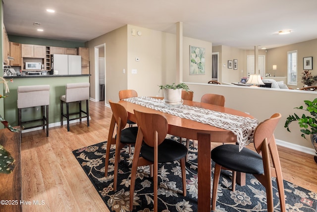 dining room with baseboards and light wood-style floors