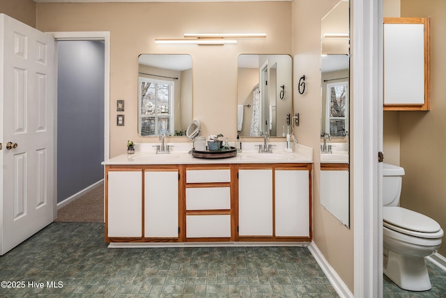 bathroom with a sink, plenty of natural light, and toilet