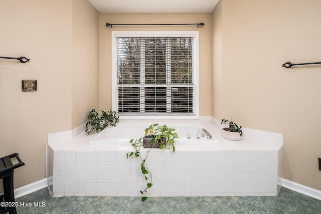 bathroom with tile patterned floors and a bath