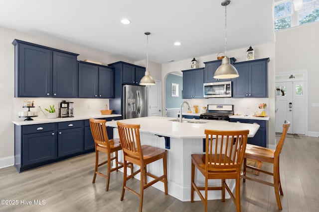 kitchen with a sink, blue cabinetry, and appliances with stainless steel finishes