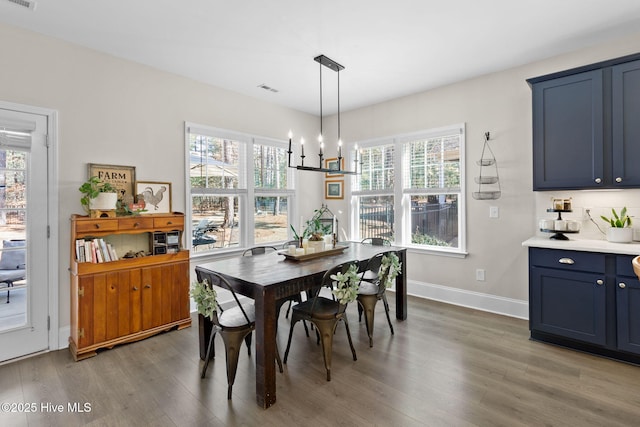 dining room featuring visible vents, baseboards, a healthy amount of sunlight, and wood finished floors