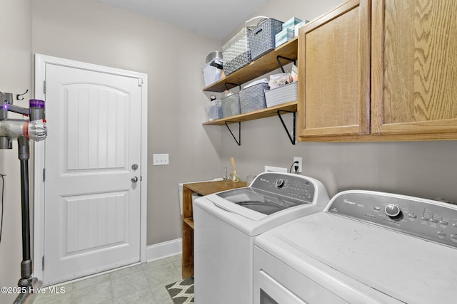 laundry area featuring cabinet space, light tile patterned floors, independent washer and dryer, and baseboards