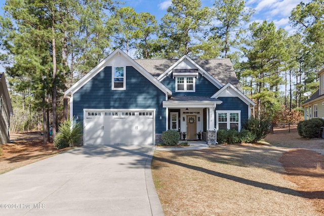 craftsman inspired home with concrete driveway, a garage, and roof with shingles