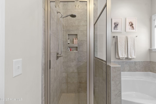 bathroom featuring a bath and a shower stall