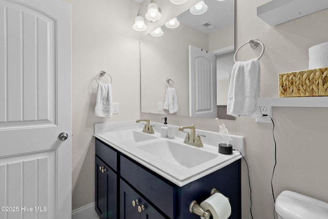 bathroom featuring vanity, toilet, and visible vents