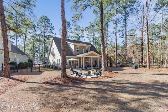 back of property featuring a patio area, a fire pit, and fence