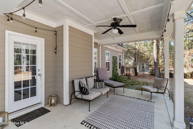 view of patio with an outdoor living space, ceiling fan, and fence