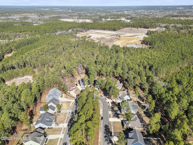 drone / aerial view featuring a view of trees and a residential view