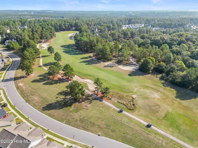 bird's eye view featuring a forest view and view of golf course