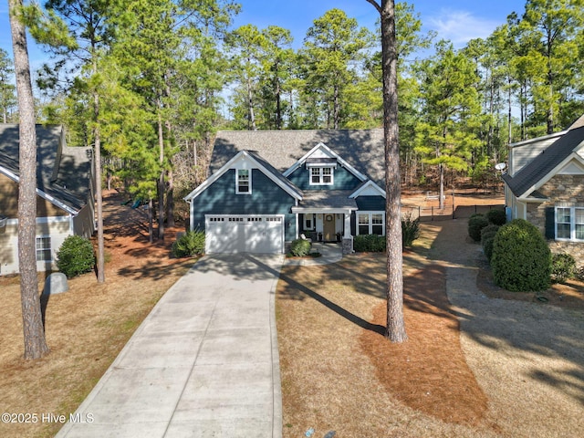 view of front of home featuring driveway and roof with shingles